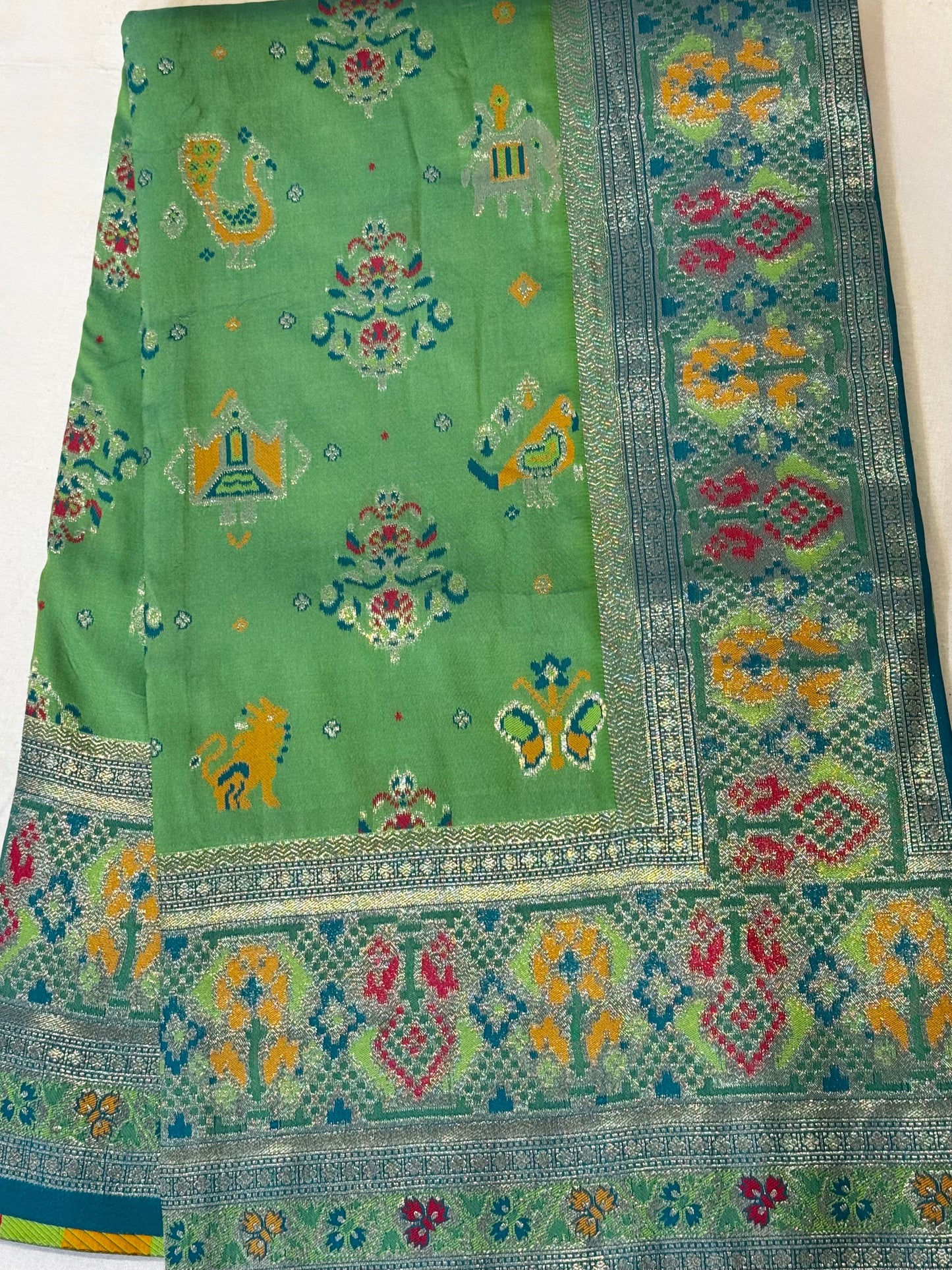 Morni – A Handwoven Green Patola Saree with Peacock and Elephant Motifs, Accented by a Teal-Silver Zari Border