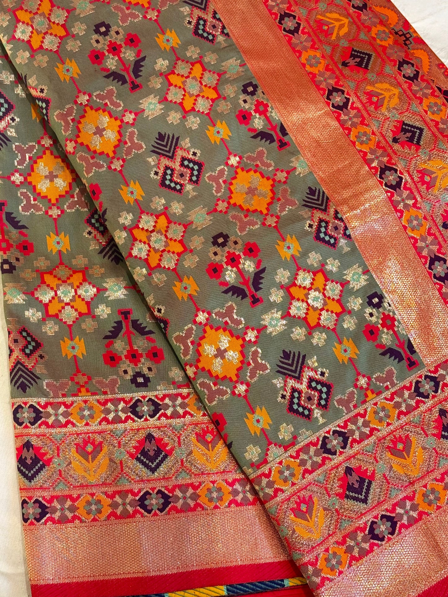 Tara – A Handwoven Green Patola Saree with Copper-Pink Border and Vibrant Ikat Motifs