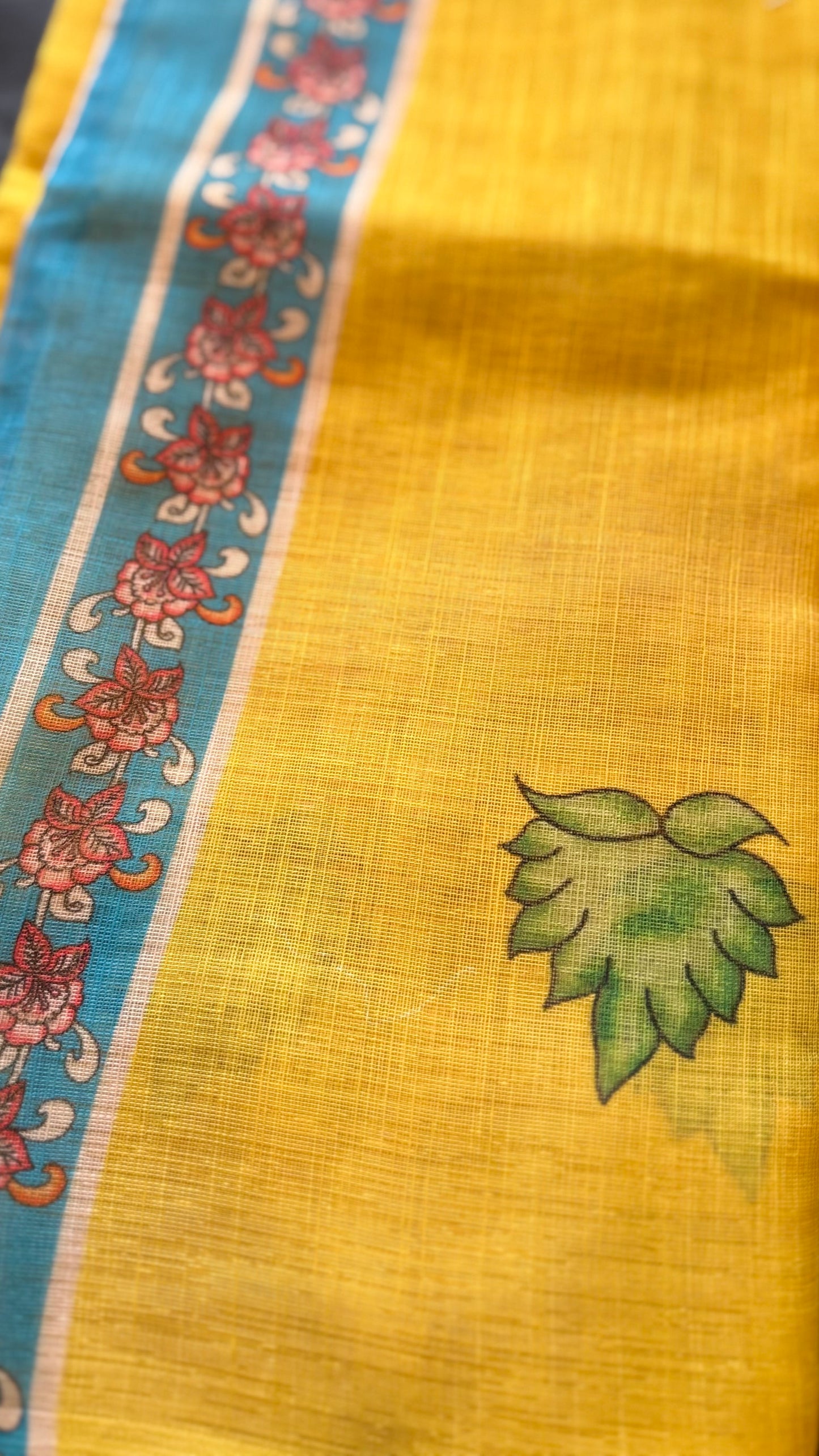 Sunayana – A Vibrant Yellow Saree with Blue Floral Border and Tassels